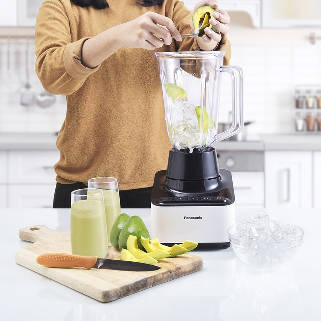 Henkilö tekee blenderillä smoothieta